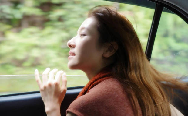 李兰迪坐在车中,风吹气她的长发。